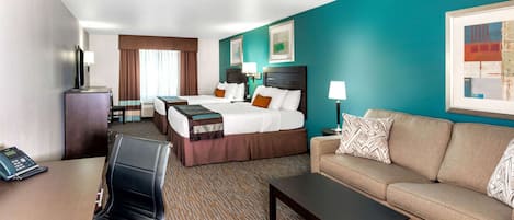A hotel room with two beds, a sofa, a desk, and a telephone.