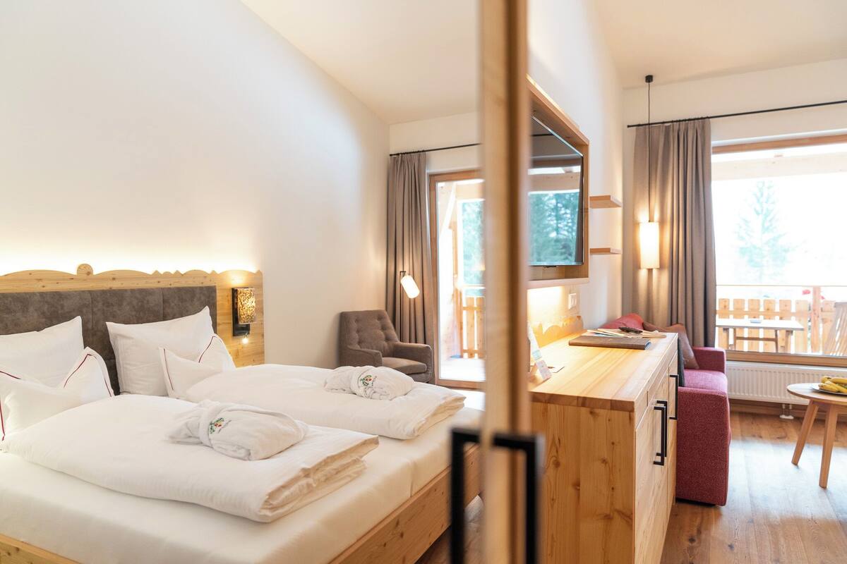 Une chambre d’hôtel avec un lit, un bureau, une chaise et une vue sur l’extérieur.