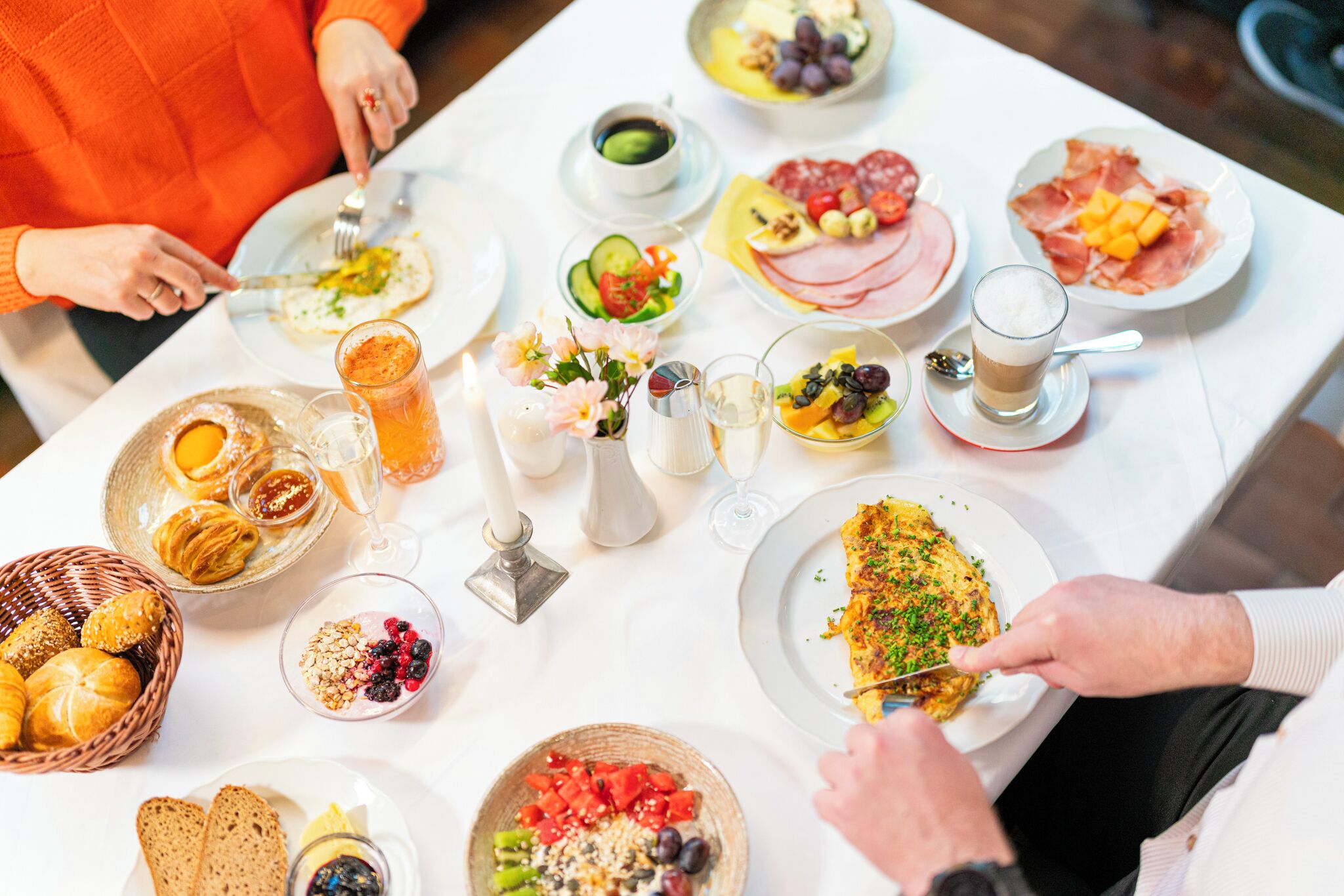 A breakfast setting with various food items and drinks on a table.