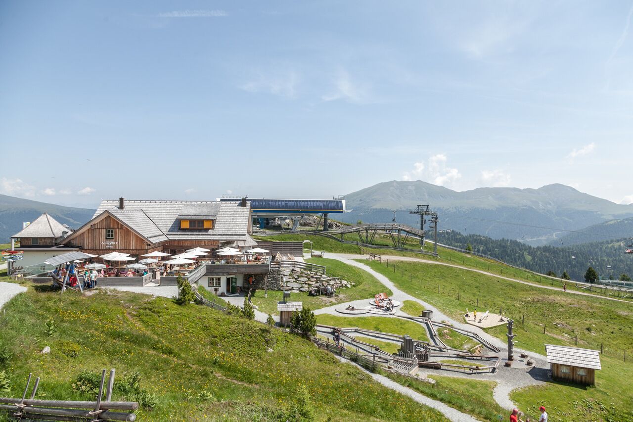 Ein Berggasthof mit Restaurant und Außenbereich, eingebettet in eine reizvolle Berglandschaft.