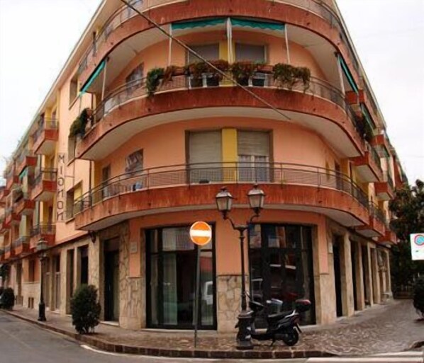 A multi-story building with balconies, a no entry sign, and a parked scooter. - Hotel Mignon (Alassio)