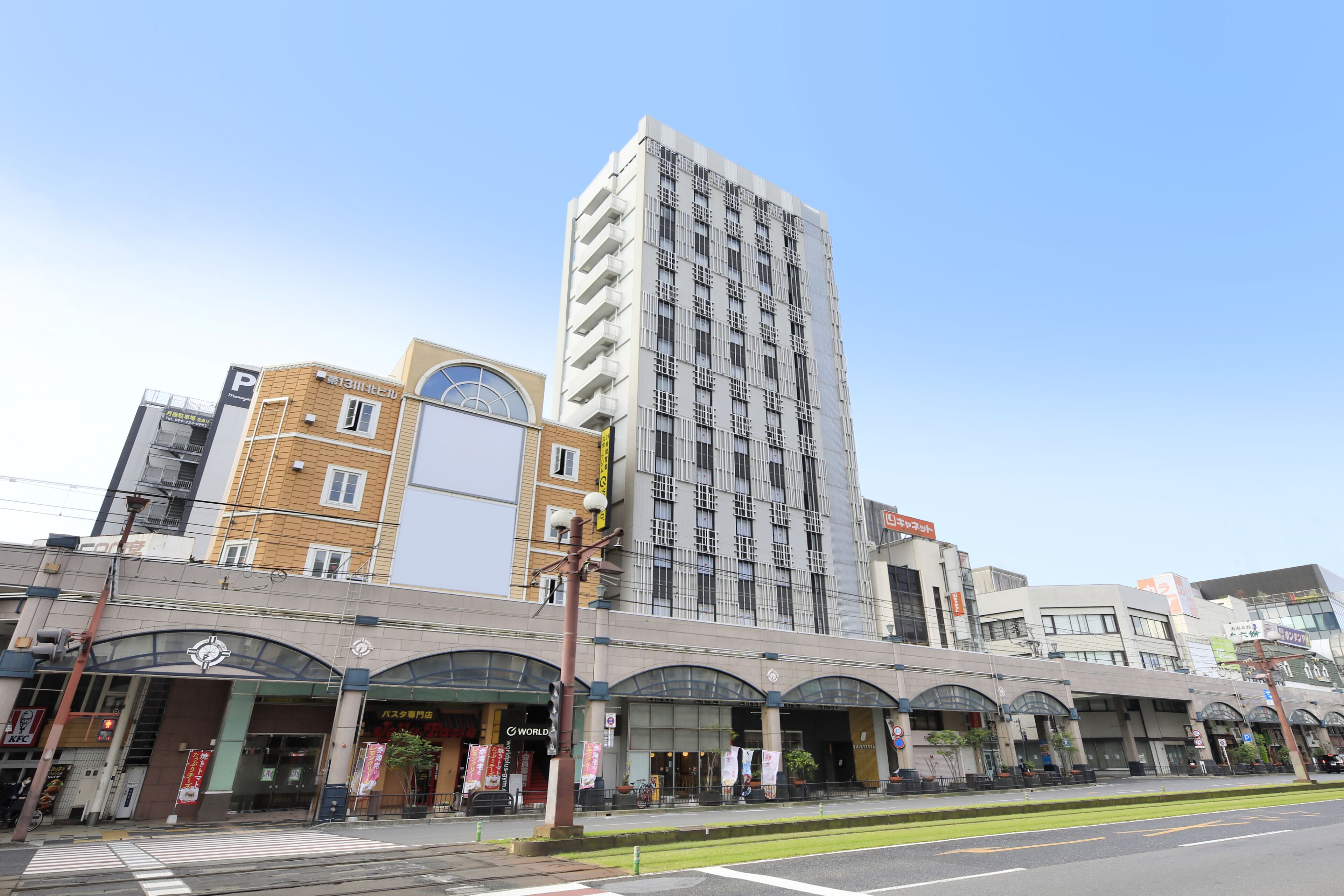 A multi-story building with a modern architectural design, featuring a prominent entrance with a curved facade and large windows.