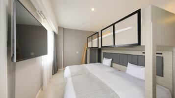 Habitación de hotel con una cama grande, un televisor de pantalla plana montado en la pared y una escalera de madera apoyada contra la pared.