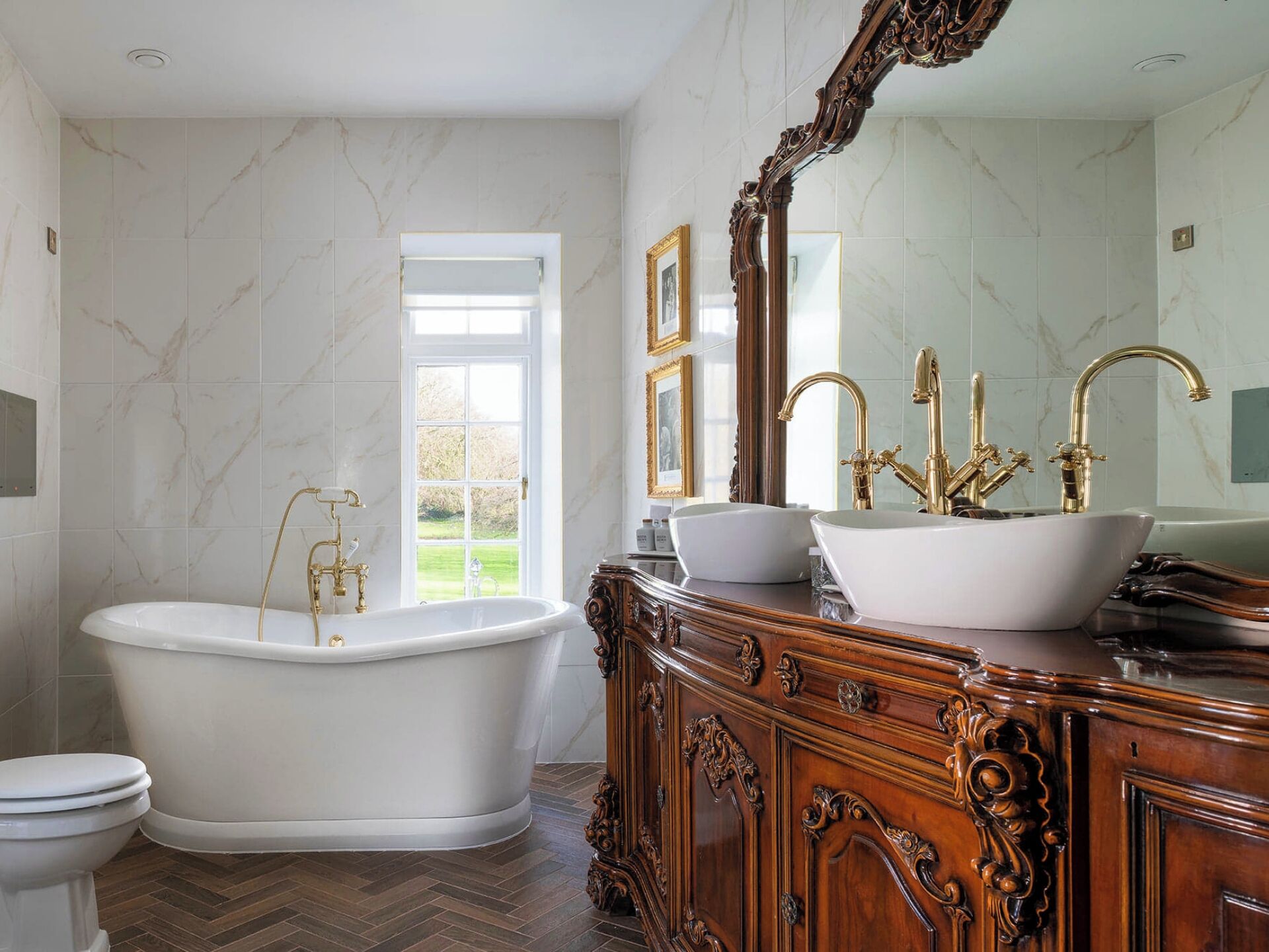 A bathroom with a freestanding bathtub, a vanity with a sink, and a large mirror.