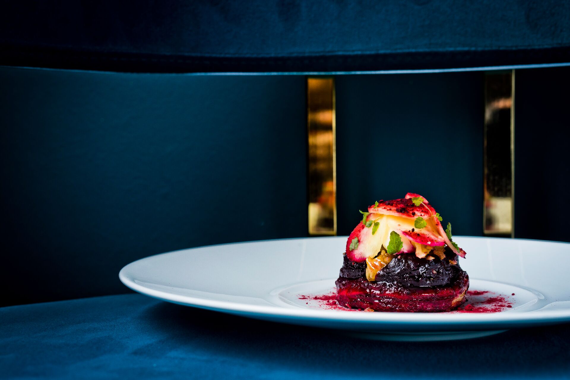 A dessert on a white plate with a dark blue background.