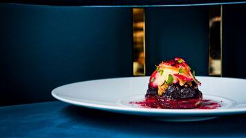 A dessert on a white plate with a dark blue background.