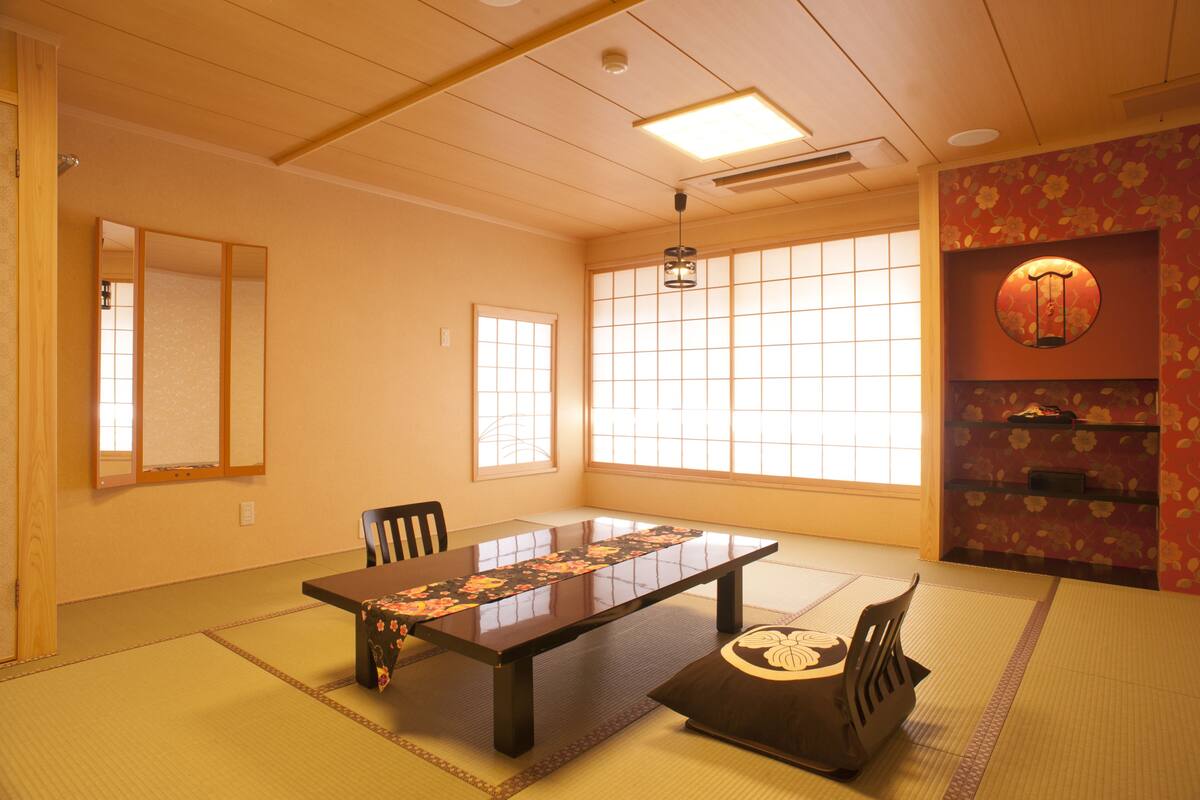 A traditional Japanese room with tatami flooring, a low table, and shoji screens.