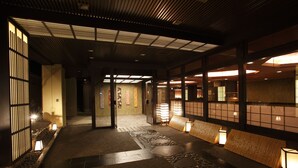Een traditioneel Japans interieur met tatami vloeren, schuifdeuren en sfeervolle verlichting.