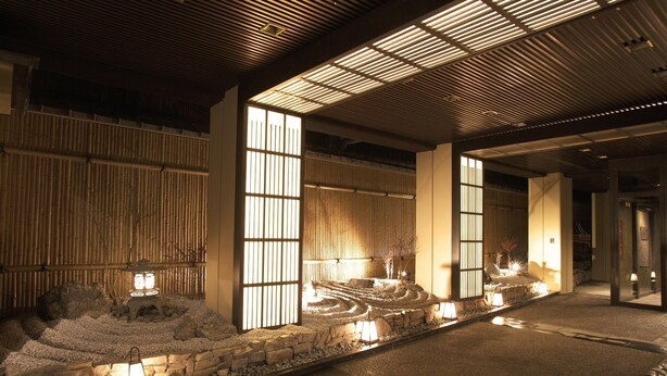 Een traditionele Japanse tuin met een pad van stenen, lantaarns en bamboe omheiningen.