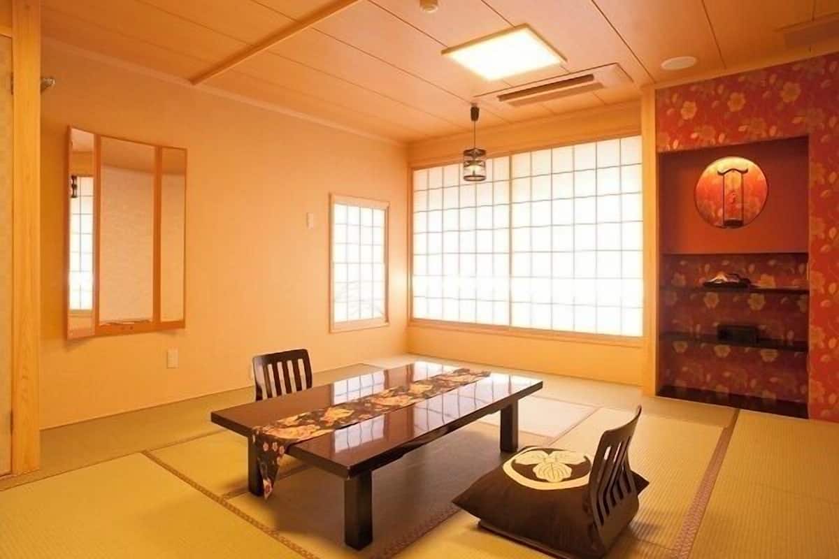 A traditional Japanese room with tatami flooring, a low table, and a sliding door.