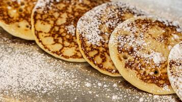 Ein Tablett mit Pfannkuchen und Puderzucker.
