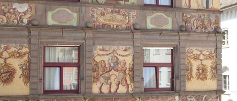 A historic building with ornate architectural details, including a coat of arms and decorative panels.