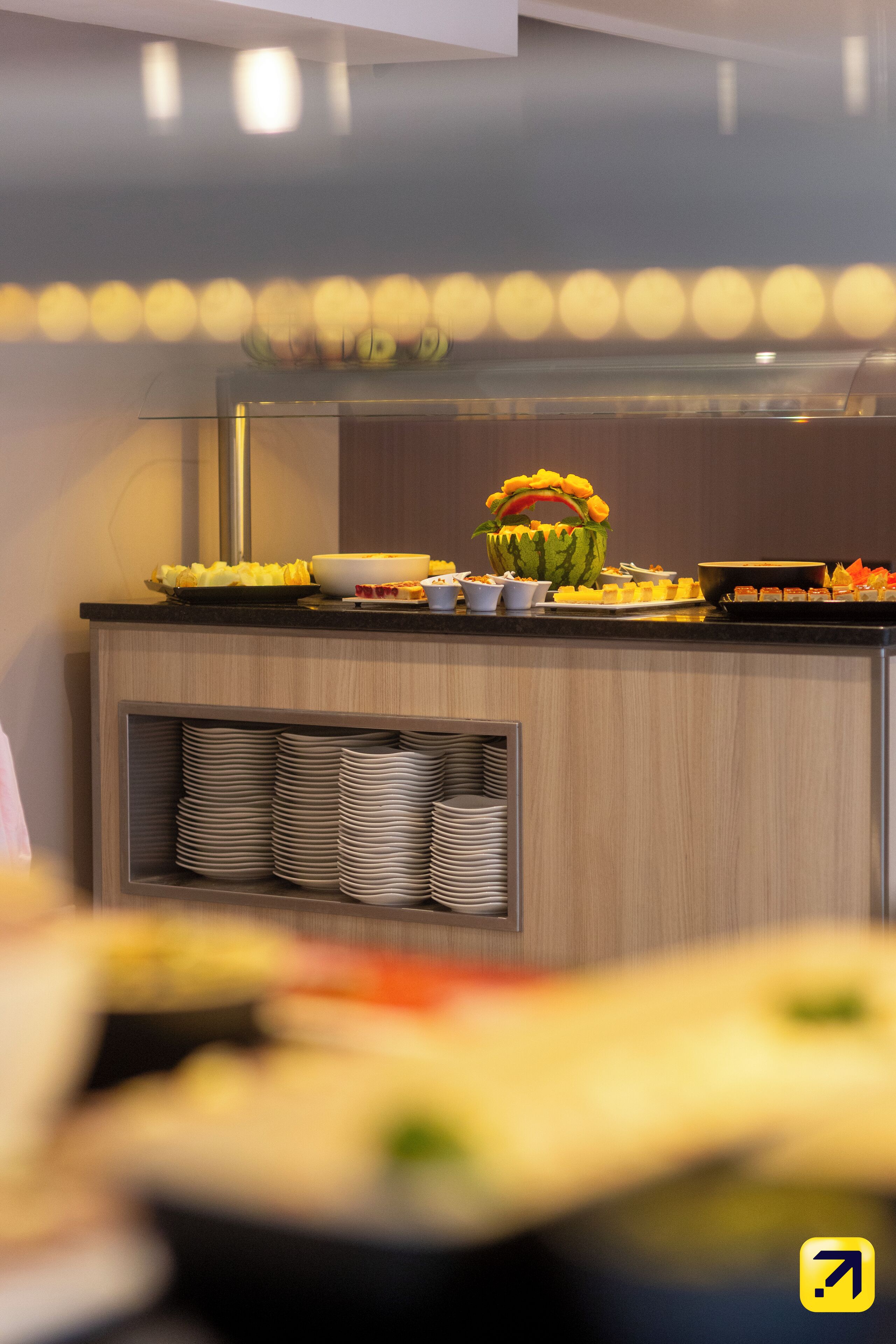 A buffet setup with various food items and a decorative watermelon centerpiece.