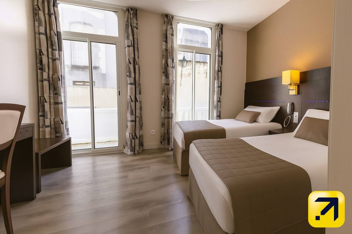 A hotel room with two beds, a desk, and a chair.