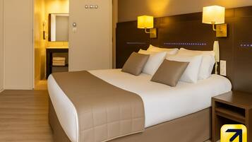 Ein modernes Hotelzimmer mit einem großen Bett, zwei Nachttischlampen und einem hölzernen Kopfteil.
