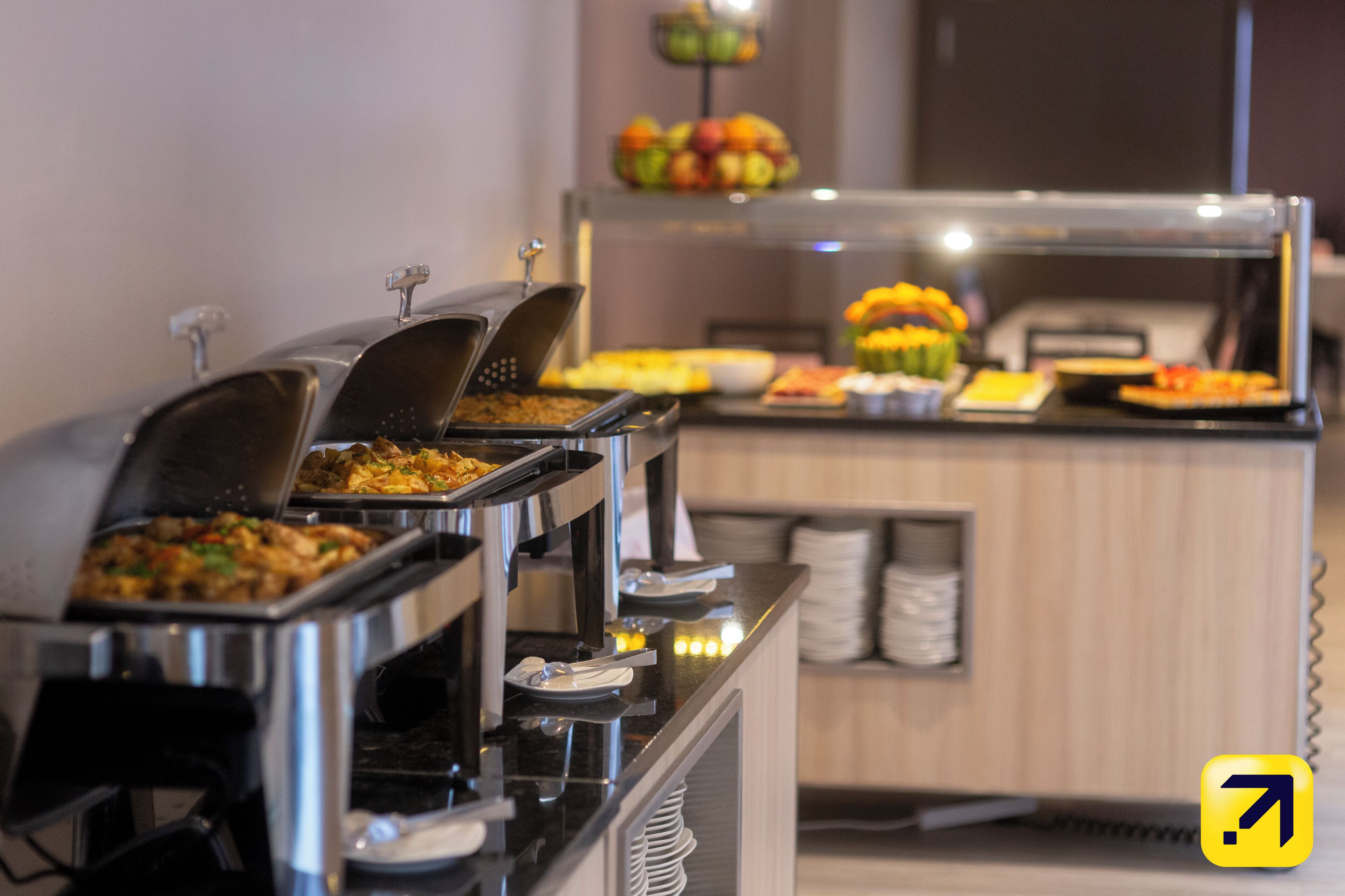 A buffet with various food items and a fruit display.