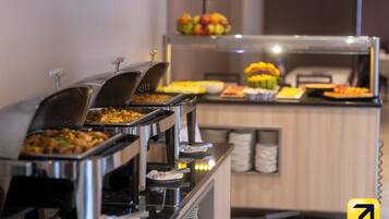 A buffet with various food items and a fruit display.