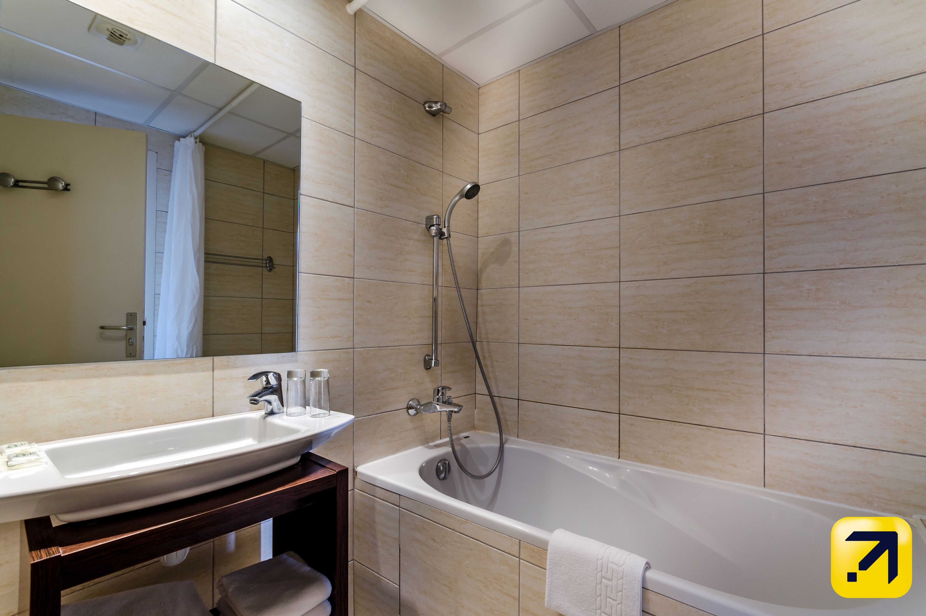 Une salle de bain avec une baignoire, un lavabo et un miroir.