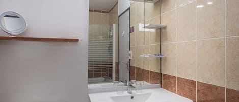 A bathroom with a white sink, a mirror, and a toilet.