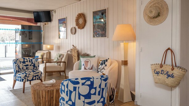 A cozy living room with a sofa, two armchairs, a coffee table, and a TV mounted on the wall. - The Original City, Hotel Cap Maya, Palais des congrès (Agde)