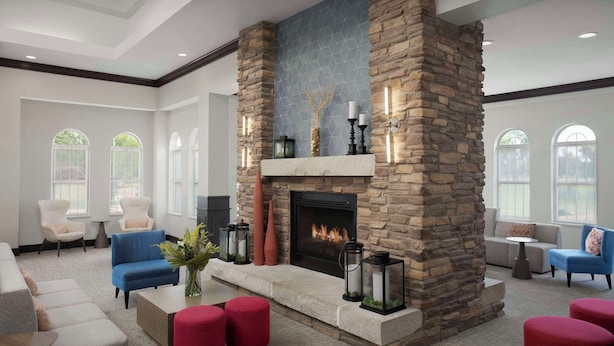 A spacious lobby with a stone fireplace, comfortable seating, and large windows. - Hilton Garden Inn Granbury (Granbury)