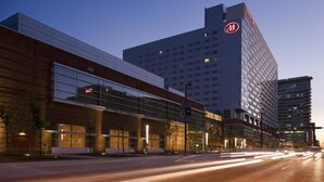 A modern hotel with a prominent logo, large windows, and a well-lit facade. - Hilton Baltimore Inner Harbor (Baltimore)