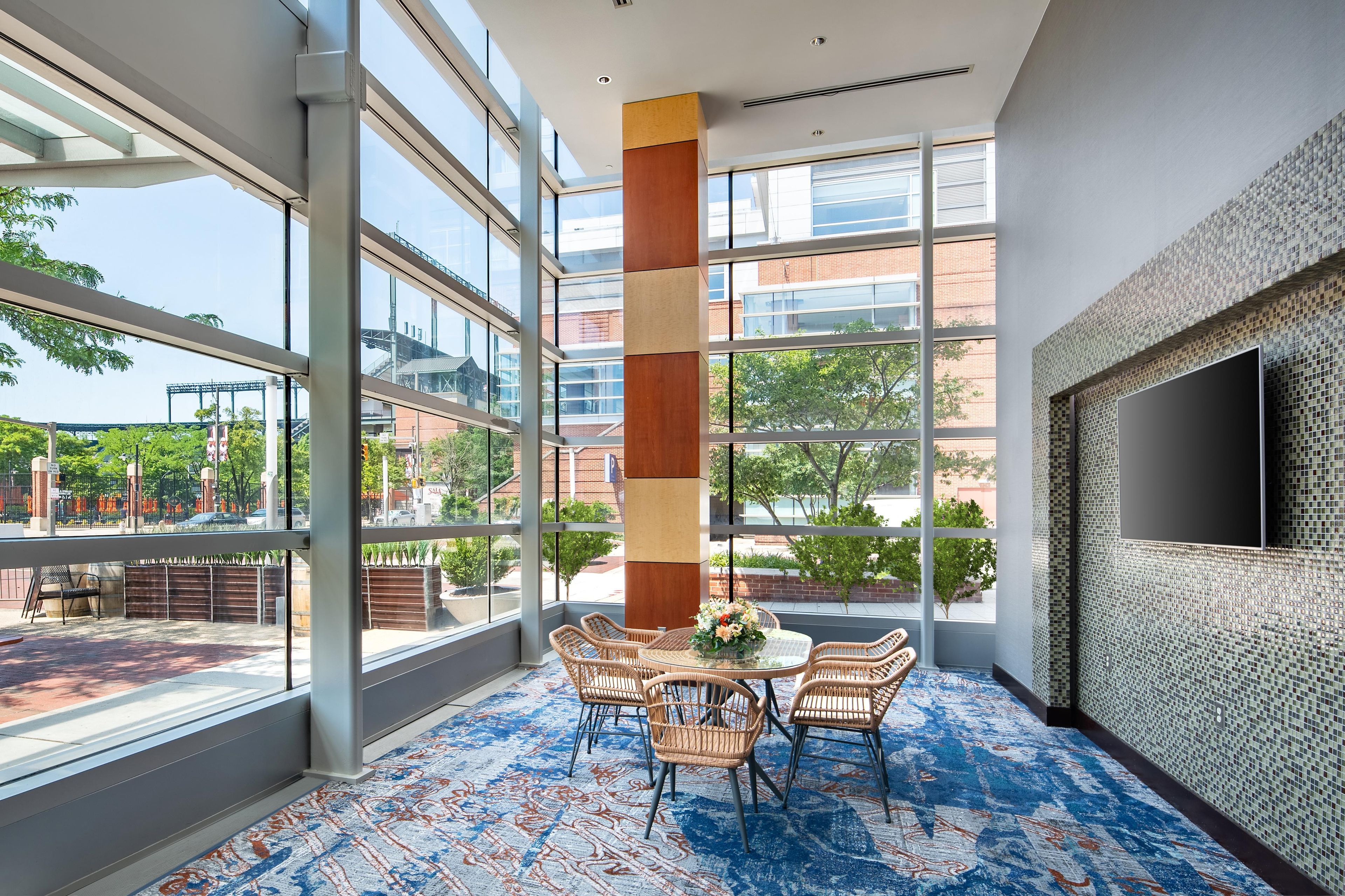A spacious room with large windows, a high ceiling, and a modern design.