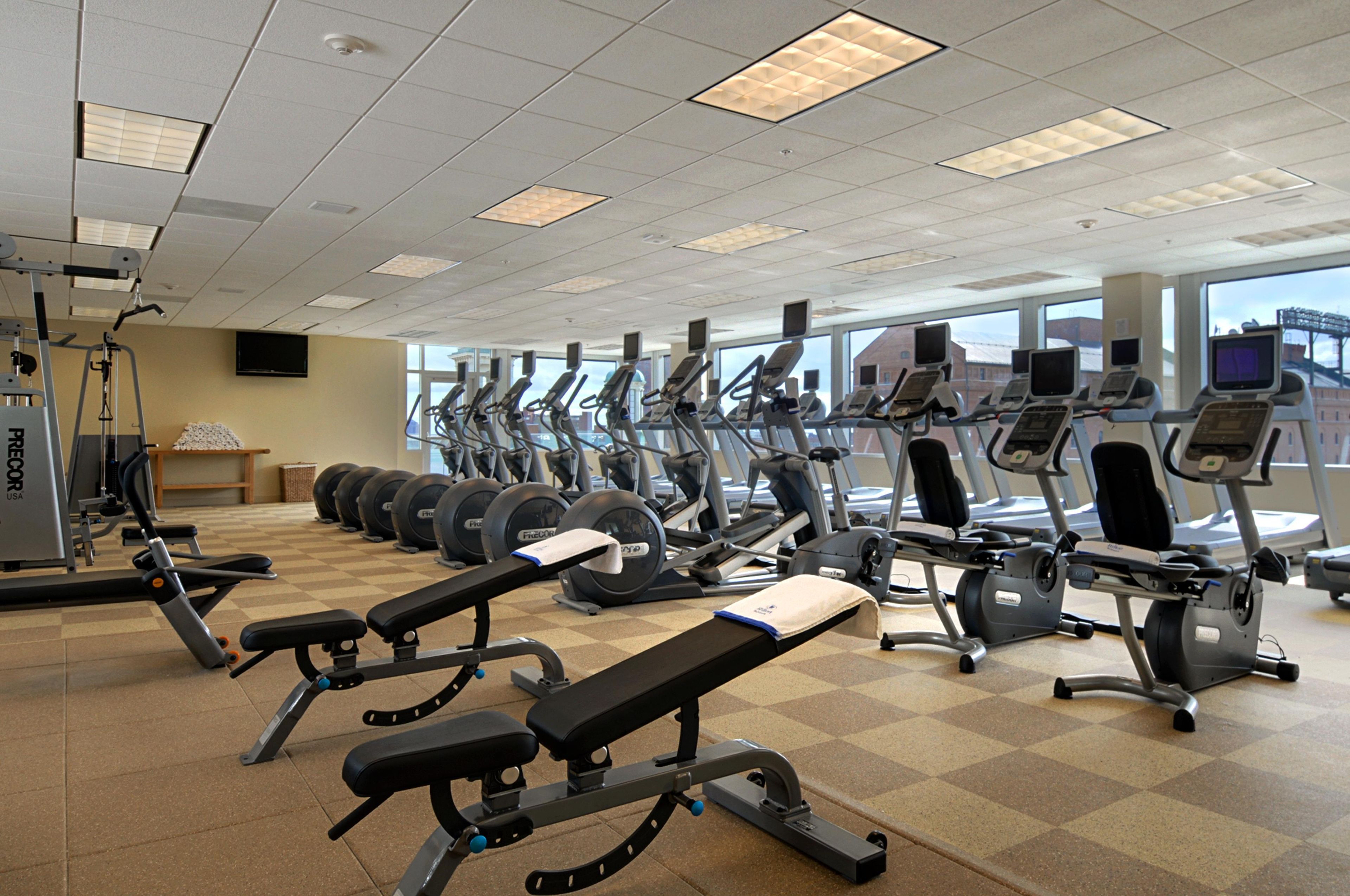 A gym with treadmills, weight machines, and a bench.