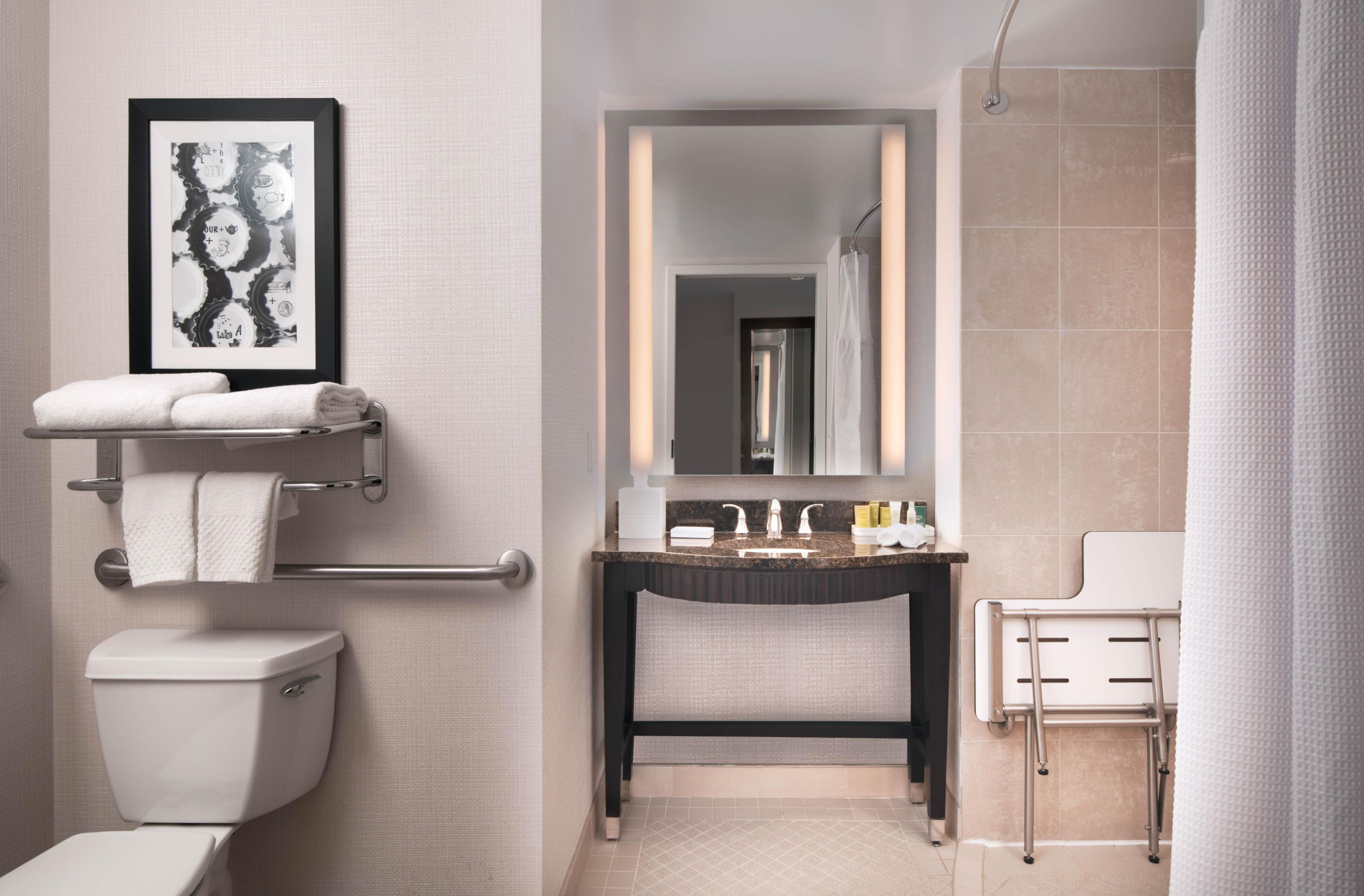 A modern bathroom with a toilet, sink, and mirror.