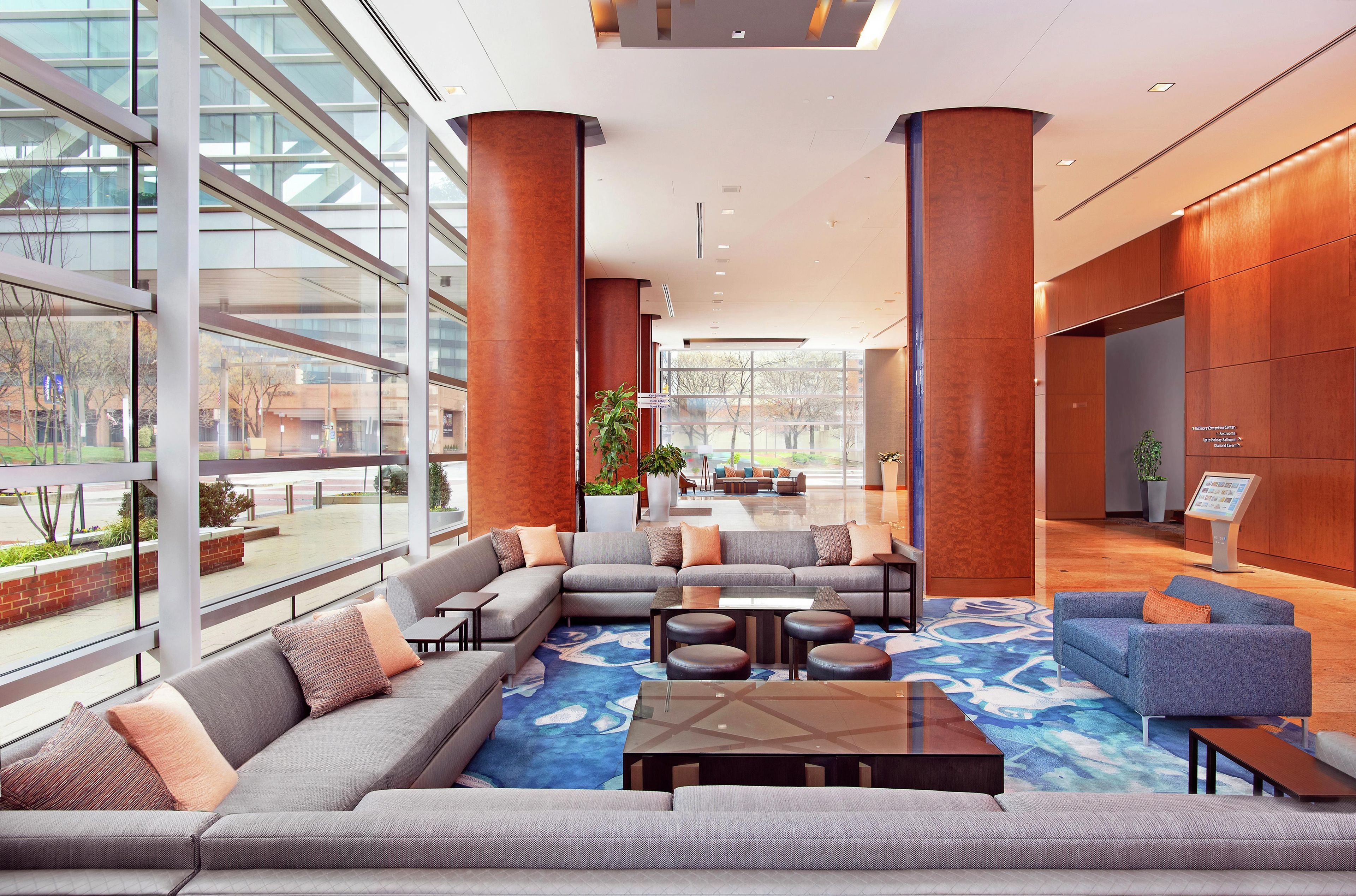 A modern lobby with a sectional sofa, a coffee table, and a reception desk.