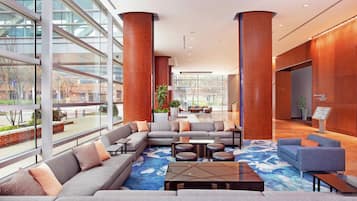 A modern lobby with a sectional sofa, a coffee table, and a reception desk.
