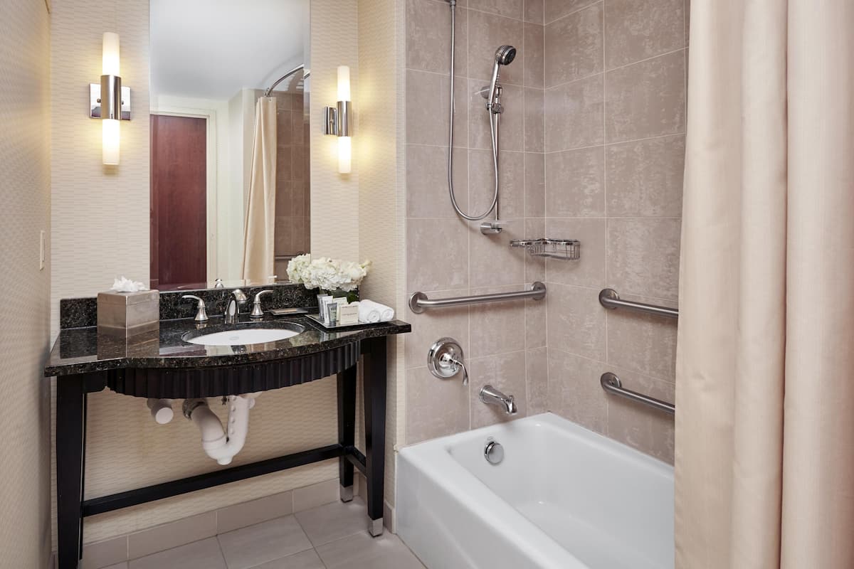 A modern bathroom with a bathtub, a vanity with a sink, and a shower area.