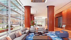 A modern lobby with a sectional sofa, a coffee table, and a reception desk. - Hilton Baltimore Inner Harbor (Baltimore)