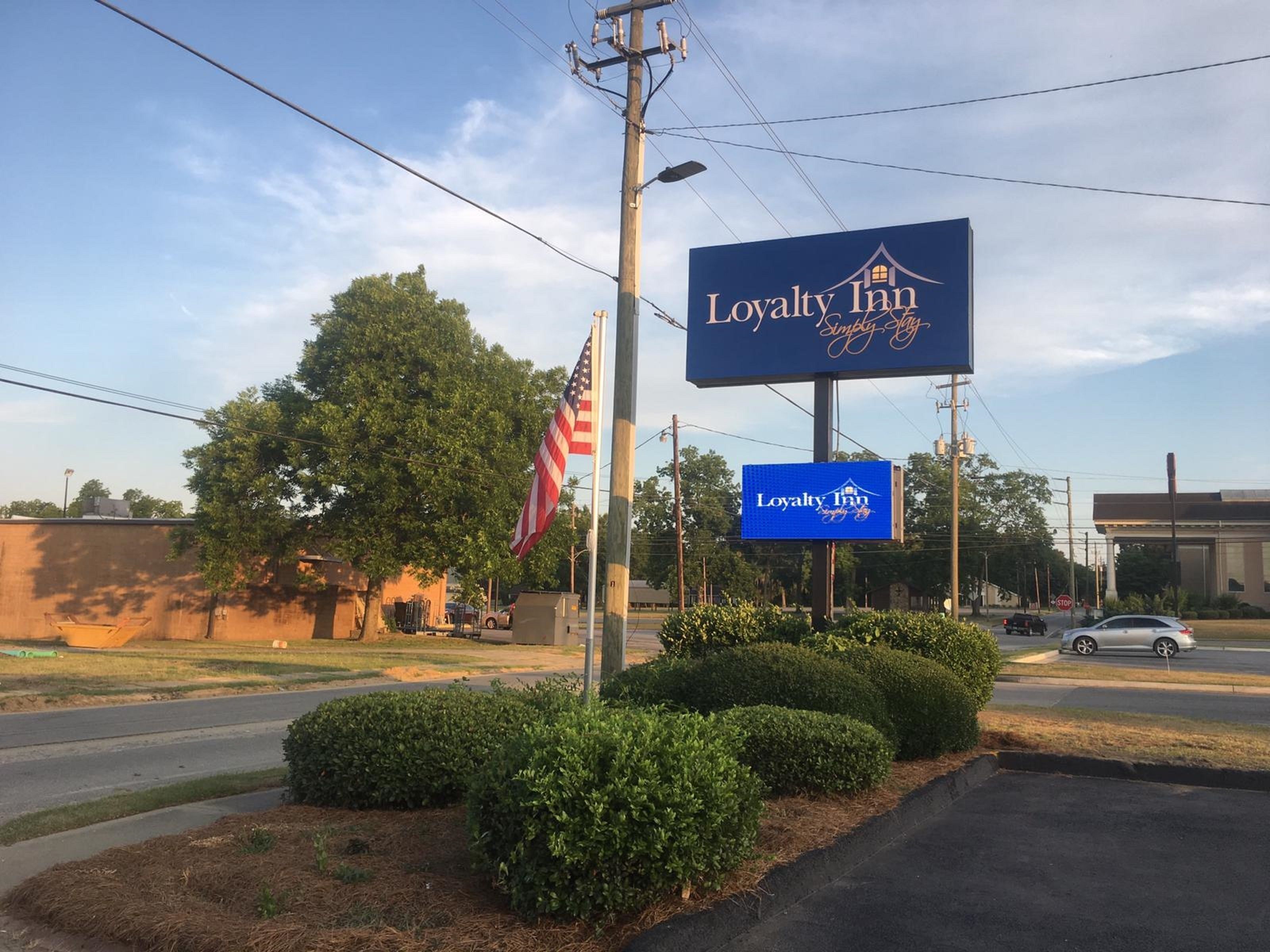 A Loyalty Inn sign with a house logo and "Simply Stay" text.