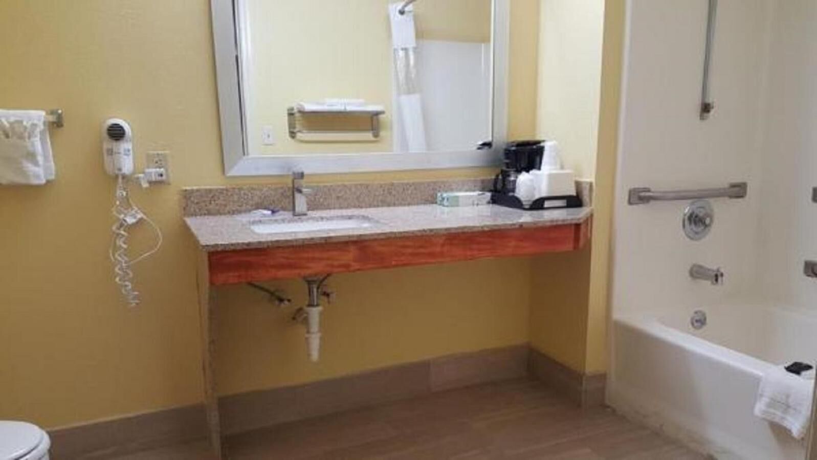 Un bagno con lavandino, specchio, asciugamano e zona doccia.