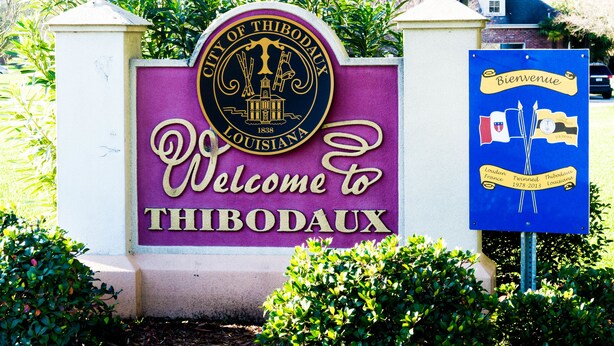 A welcome sign for Thibodaux, Louisiana, with a circular emblem and a blue welcome sign.