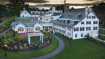 A large, multi-story building with a central courtyard, surrounded by well-maintained lawns and trees.