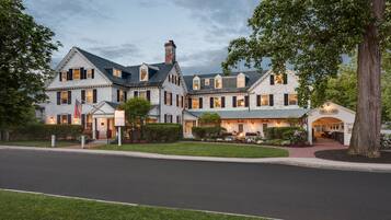 A large, historic building with multiple stories, a prominent entrance, and a well-maintained lawn.
