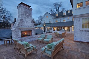 A patio with outdoor seating and a fireplace.