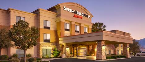 A hotel with a prominent entrance, a clear sign for Springhill Suites Marriott, and a well-maintained outdoor area with landscaping.