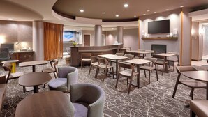 A hotel lobby with multiple seating areas, a reception desk, and a flat-screen TV mounted on the wall. - Springhill Suites by Marriott Thatcher (Thatcher)