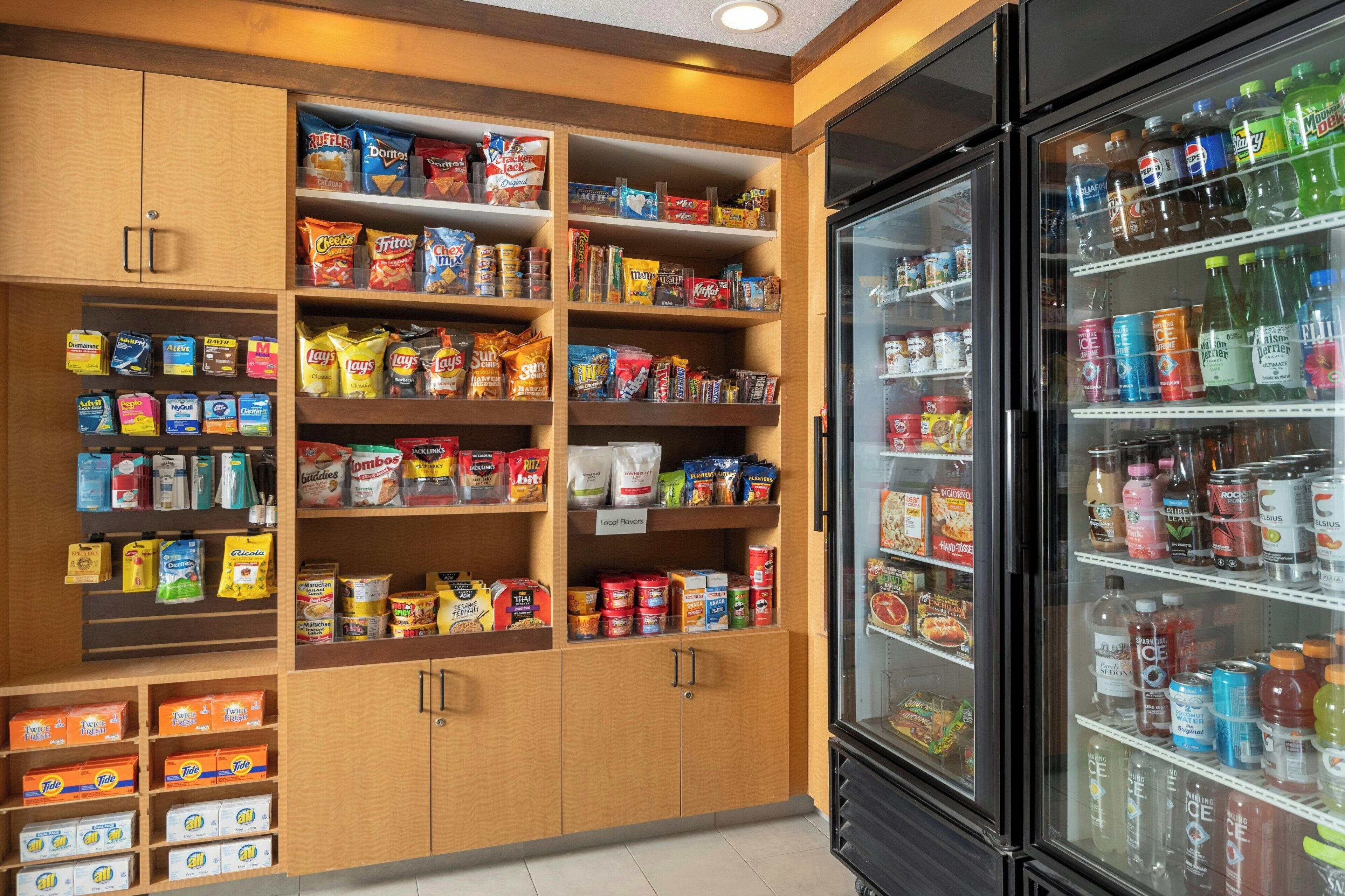 A well-stocked snack and beverage refrigerator with various brands and types of snacks and drinks.