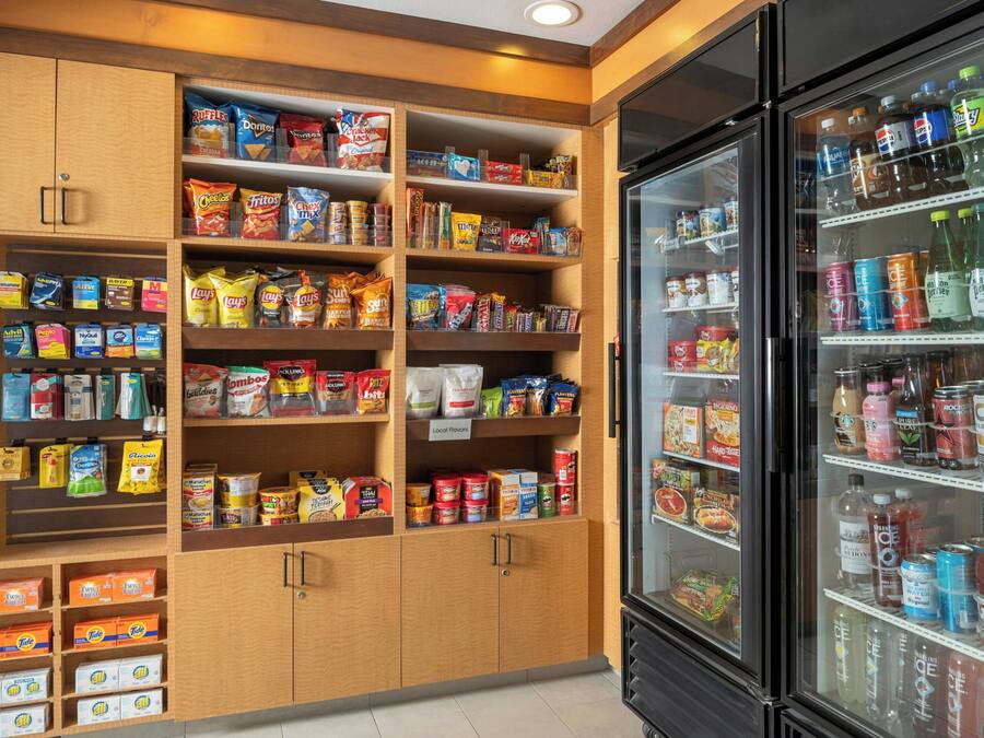A well-stocked snack and beverage refrigerator with various brands and types of snacks and drinks.