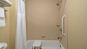 A bathroom with a bathtub, a shower curtain, a handrail, and a towel rack. - Staybridge Suites Palmdale by IHG (Palmdale)