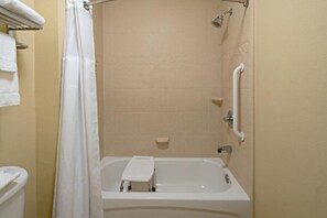 A bathroom with a bathtub, a shower curtain, a handrail, and a towel rack. - Staybridge Suites Palmdale by IHG (Palmdale)