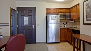 A kitchen with wooden cabinets, stainless steel appliances, and a tiled backsplash. - Staybridge Suites Palmdale by IHG (Palmdale)