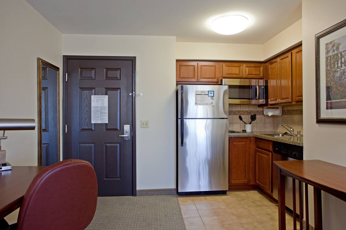 A kitchen with wooden cabinets, stainless steel appliances, and a tiled backsplash.