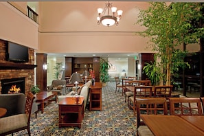 A hotel lobby with a fireplace, seating area, and a chandelier. - Staybridge Suites Palmdale by IHG (Palmdale)