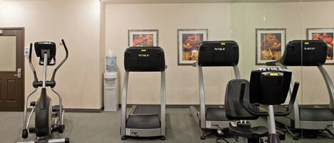 A fitness room with treadmills, an elliptical, and a water dispenser.