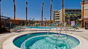 Una piscina al aire libre, sillones reclinables de piscina